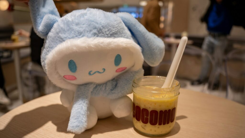 Cinnamoroll plush toy and a dessert on the table.